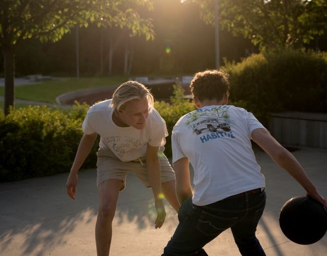 To unge menn som spiller basketball ute