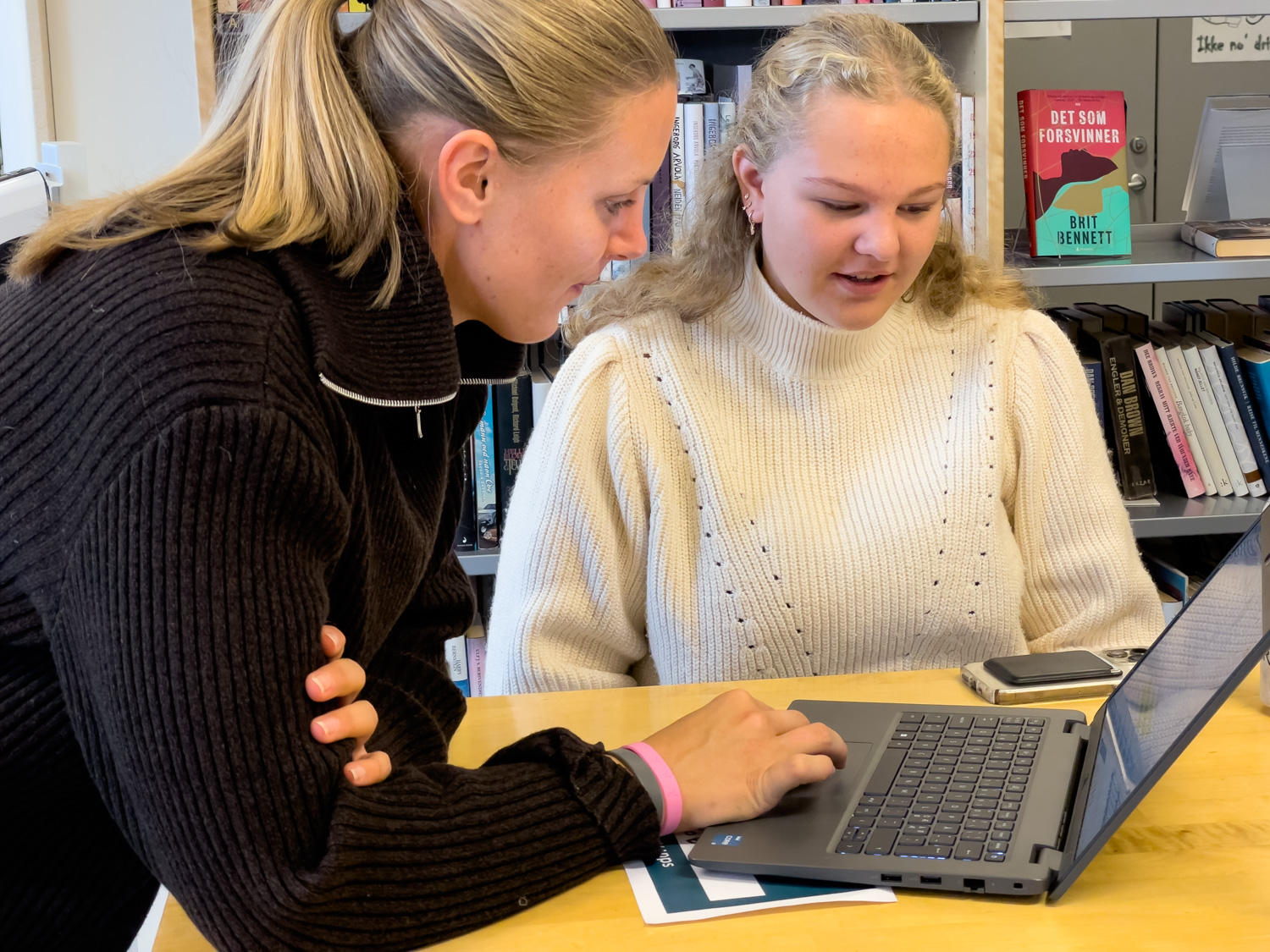 Lærer og elev samtaler over en pc