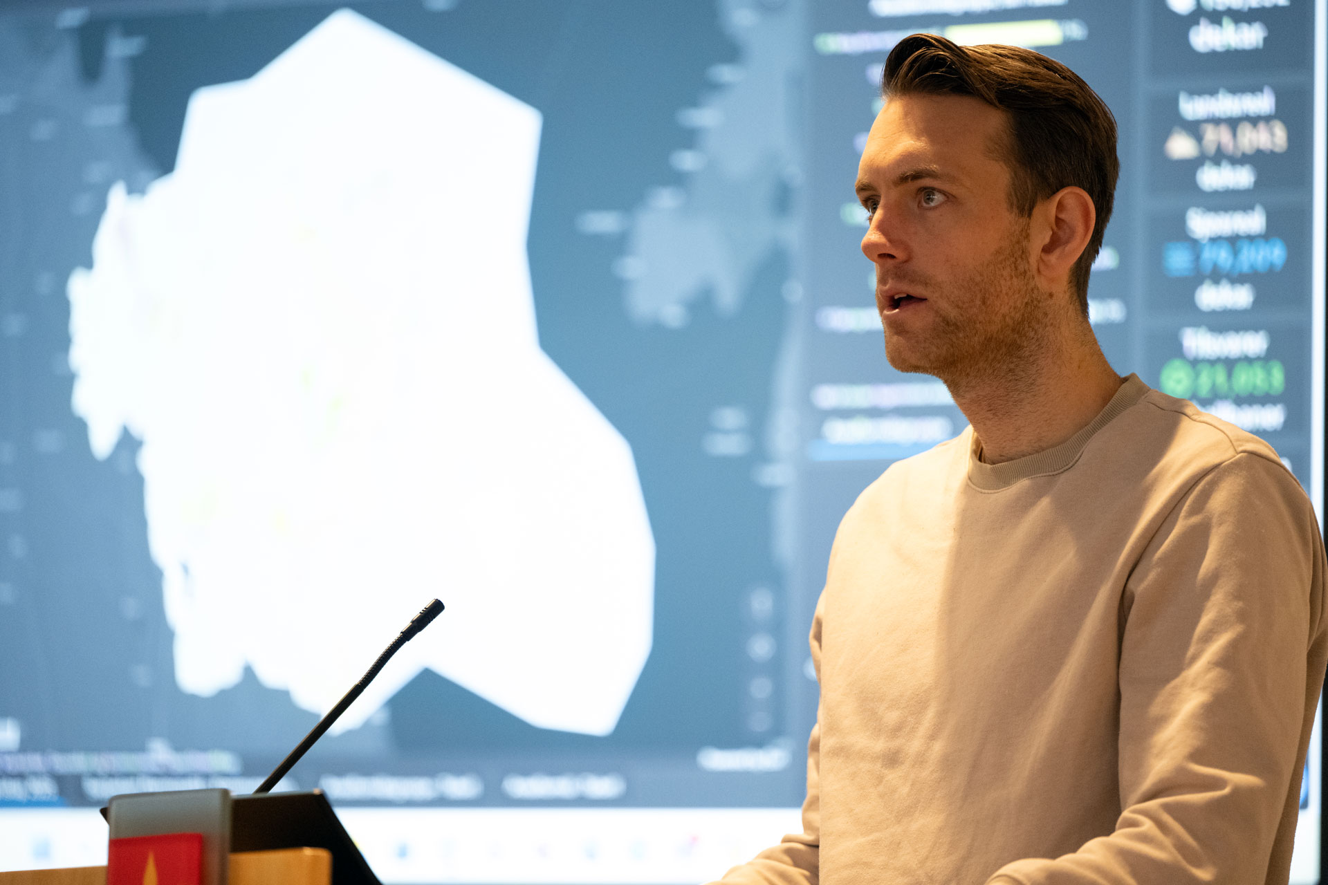 Mann presenterer med kart i bakgrunnen