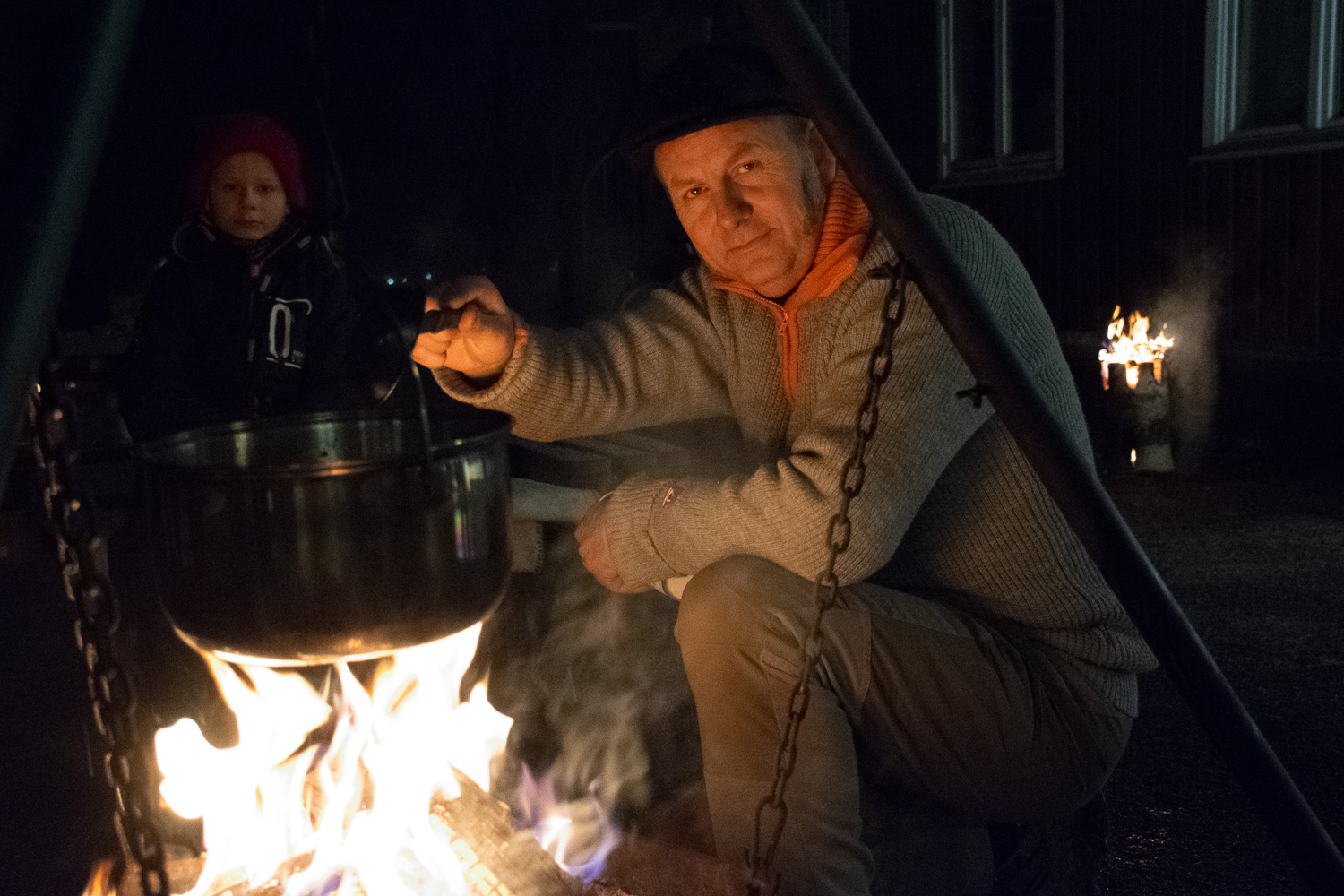 Lærer rører i gryte over bål