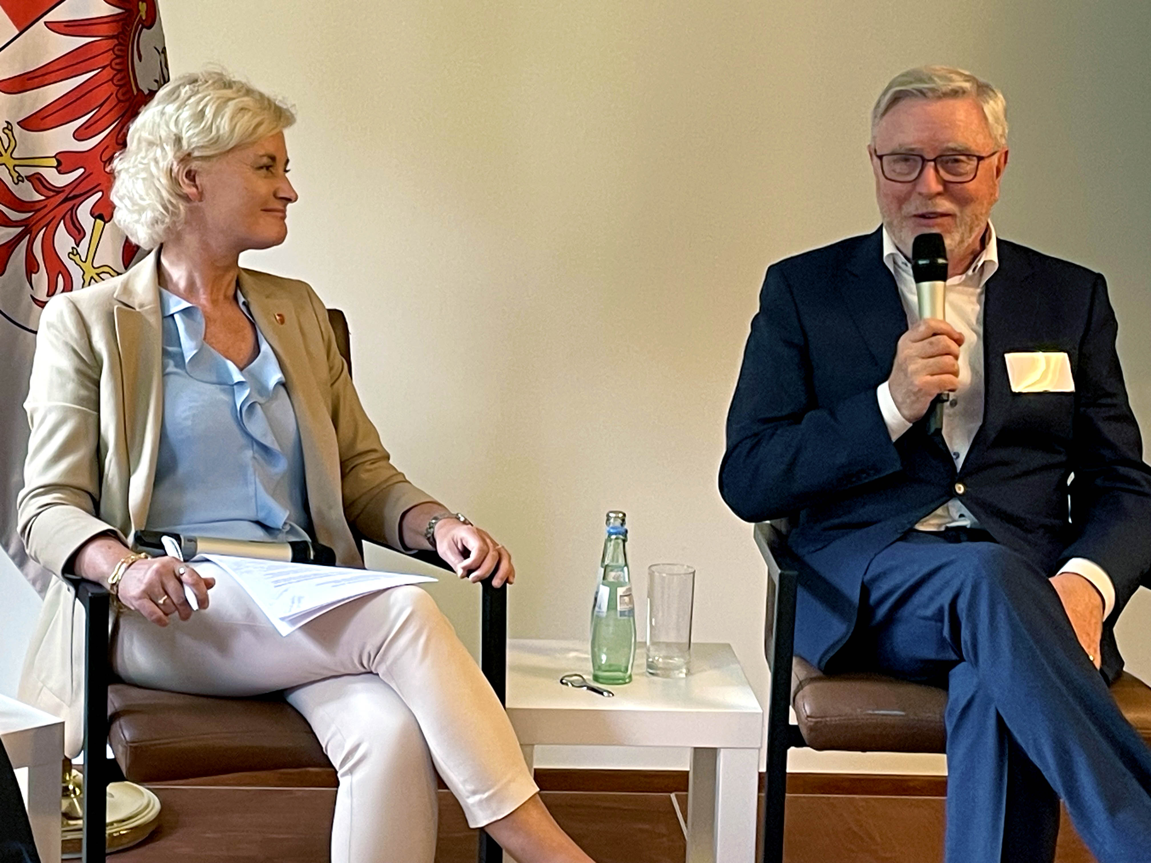 Foto av fylkesordfører Anne Strømøy sammen med EUs koordinator for ScanMed-korridoren, Pat Cox på en scene i en paneldebatt