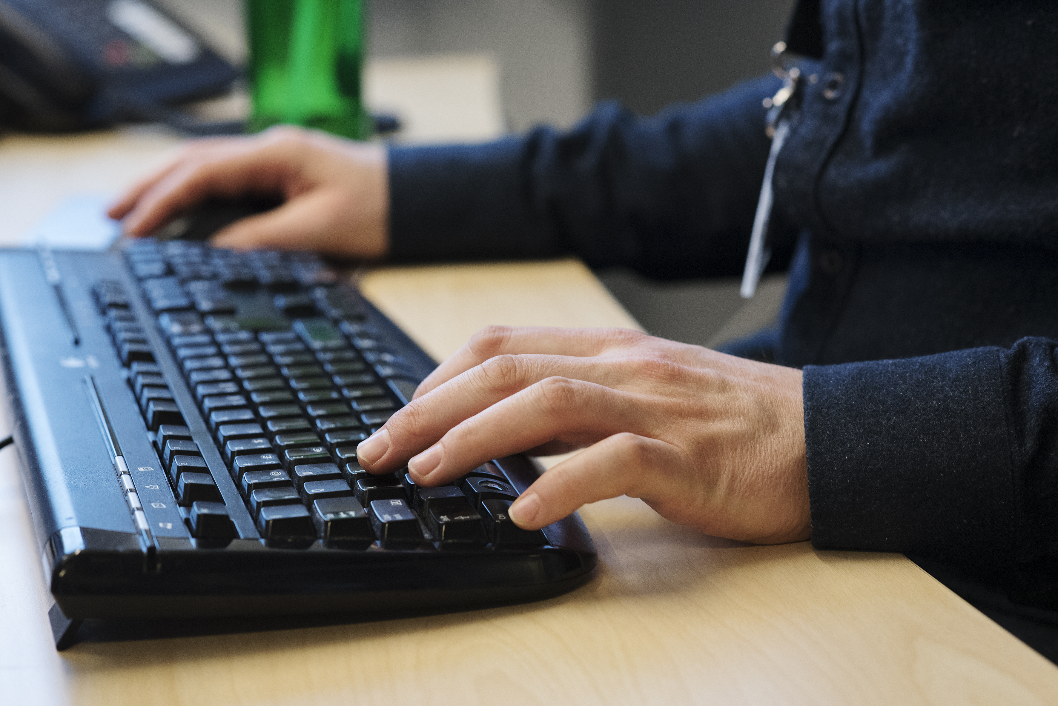 Person som sitter og skriver på et tastatur