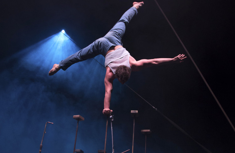 Akrobatisk danser står på én arm på scenen.