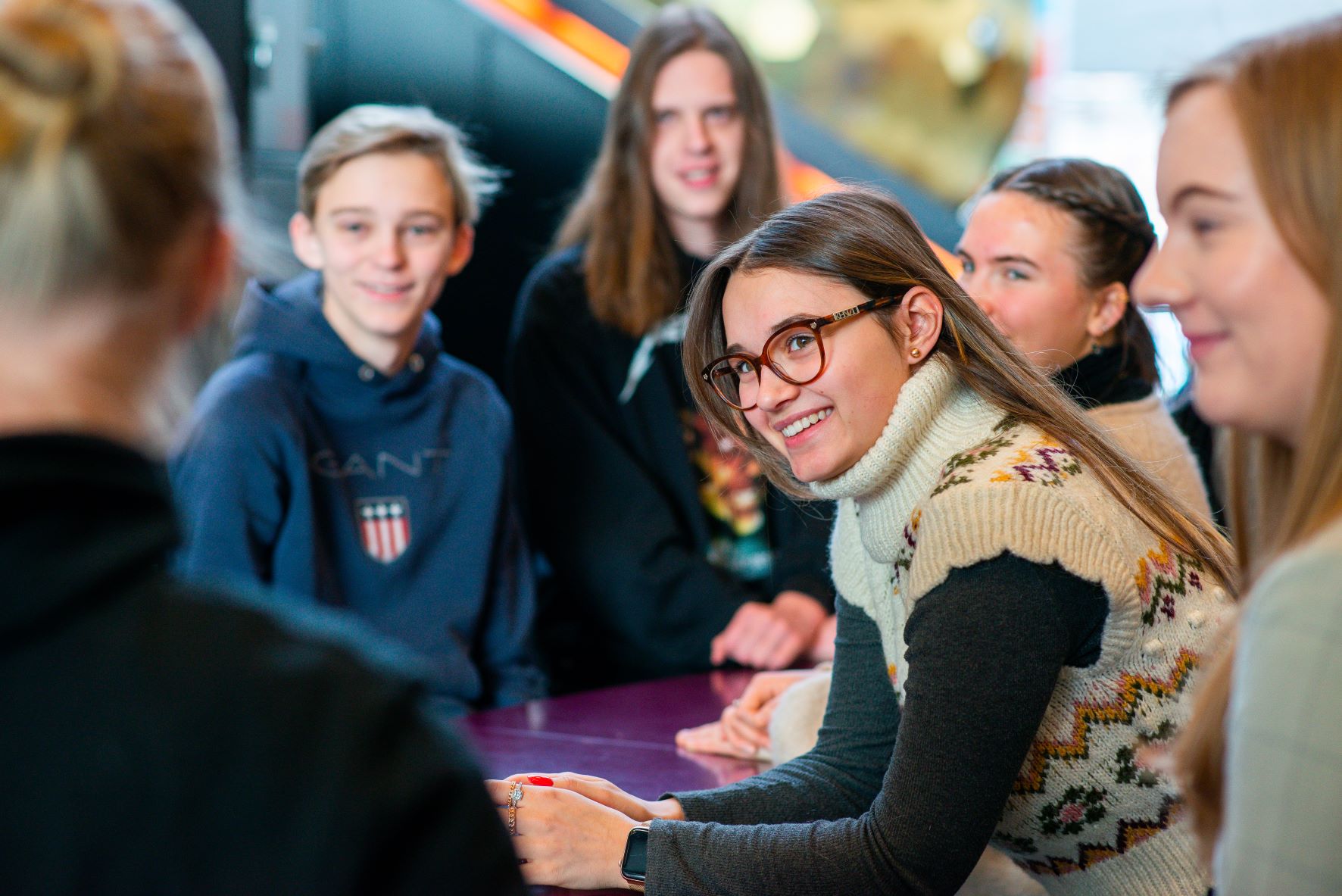 Smilende elev i dialog med medelever