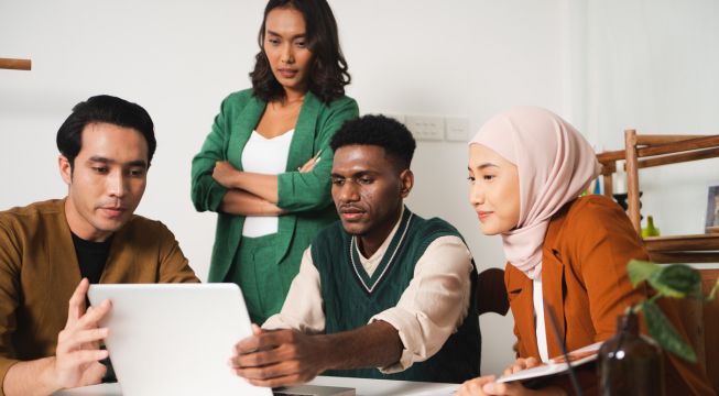 Voksne elever som ser på en PC