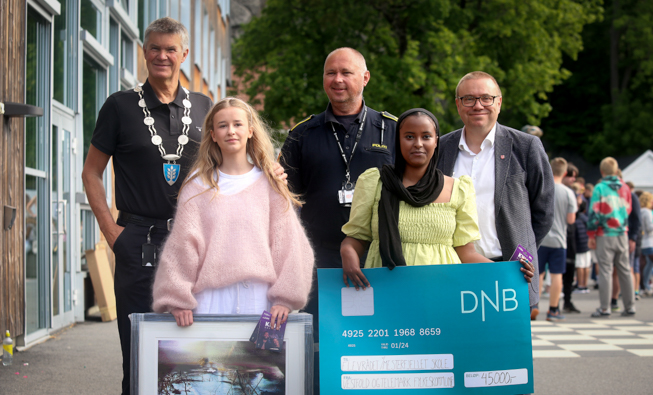 Stella Malmquist Andersen og Juweria Ali Abdi tok viser frem kunstverket og sjekken de mottok på vegne av elevrådet.