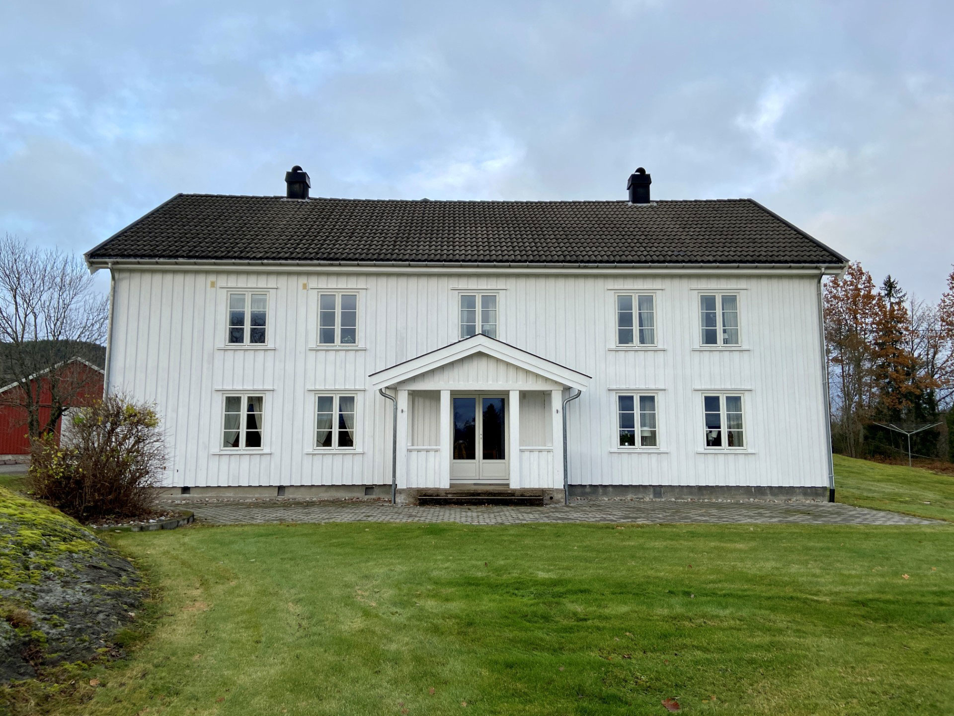 Hvitt trehus med gressplen foran