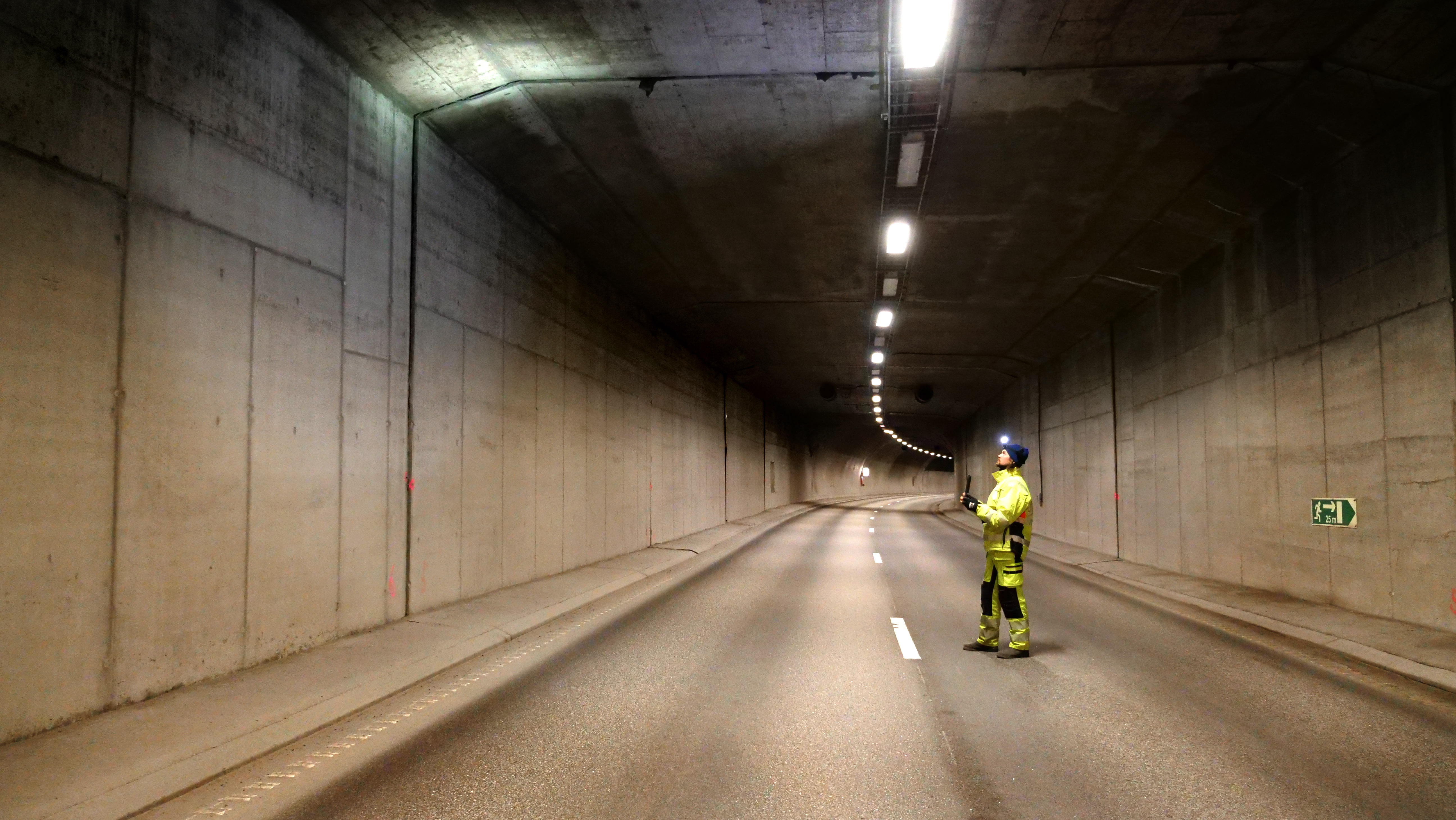 Kollega i verneutstyr fortar visuell kontroll av tunnelportalene i Frodeåstunnelen på kilensiden.