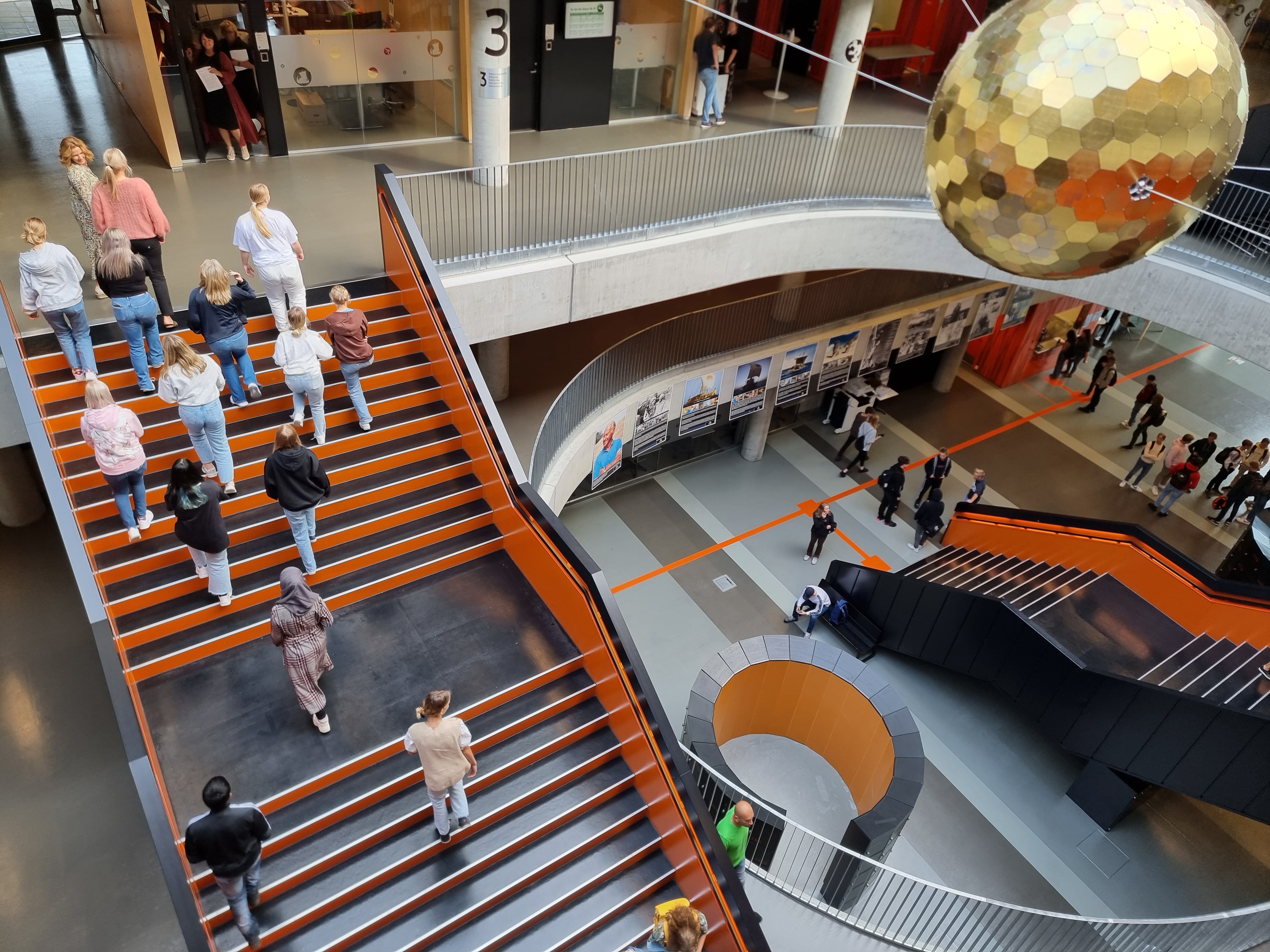 Elever i skolebygget, de går opp og ned trapp.