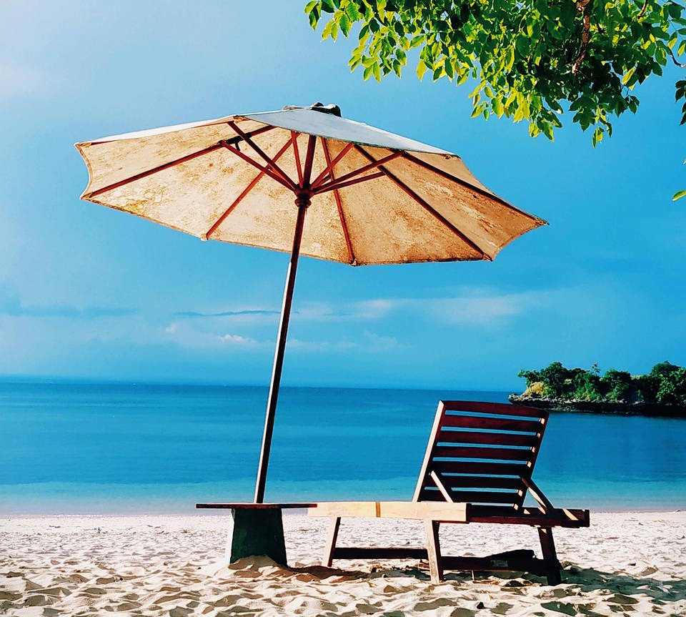 Strandstol og parasoll på en tropisk strand