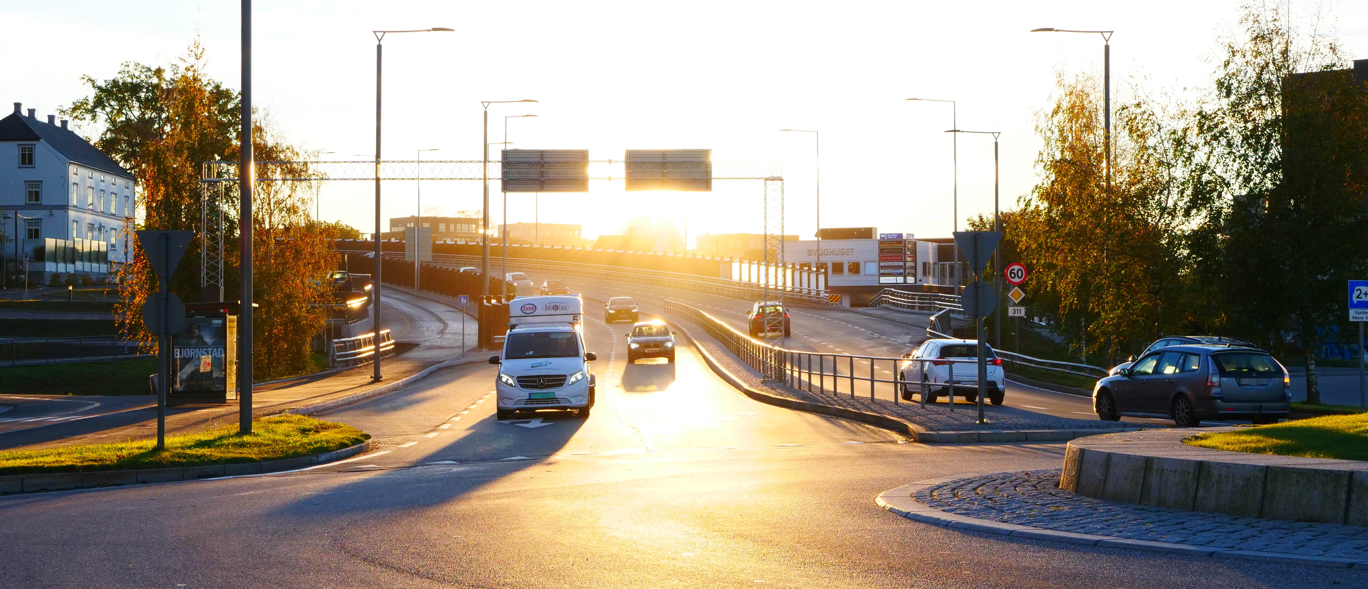Foto av Presterødbakken i soloppgang med trafikk i inn og ut av rundkjøringen