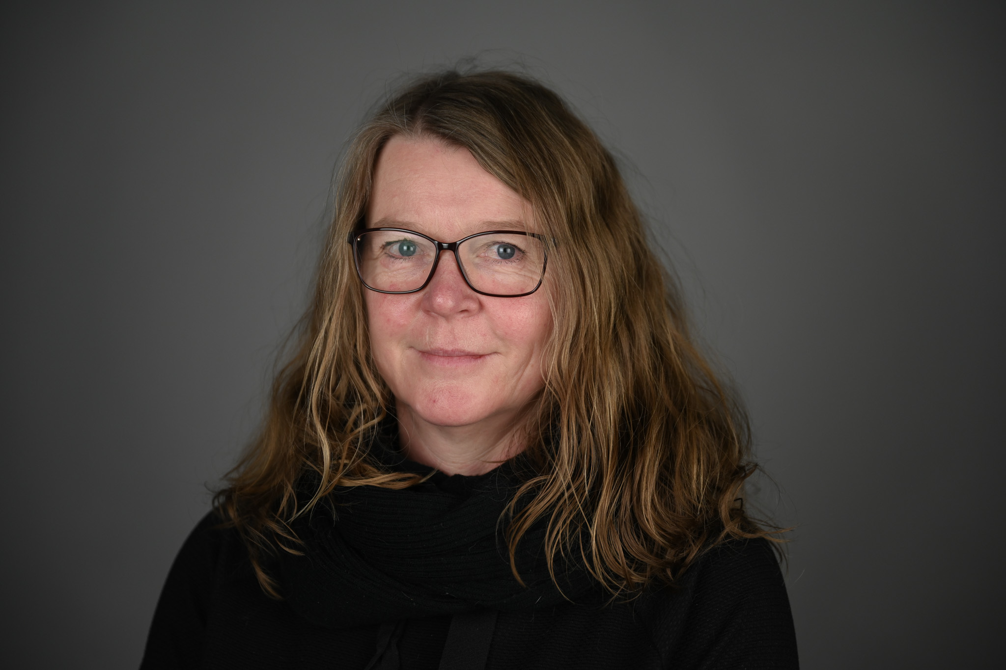 Bilde av dame med grå bakgrunn. Foto Anders Palmer