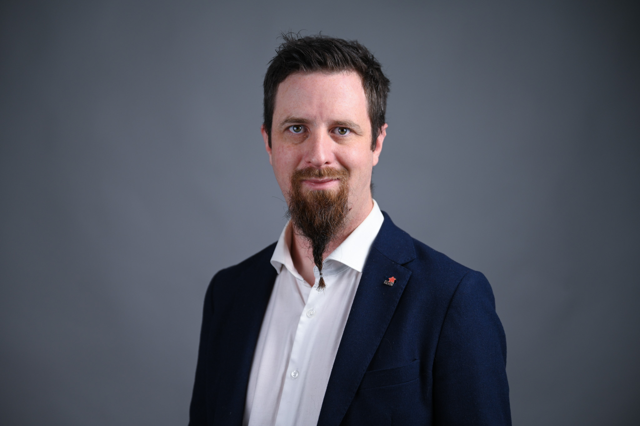 Portrett av mann med grå bakgrunn. Foto: Anders Palmer Holmen