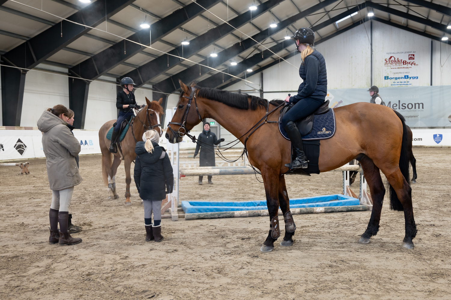 Ryttere til hest i ridehall