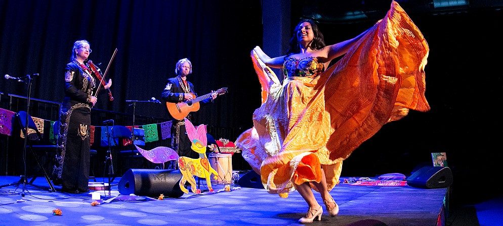 Group photo of 20-25 men and women in a leafy setting