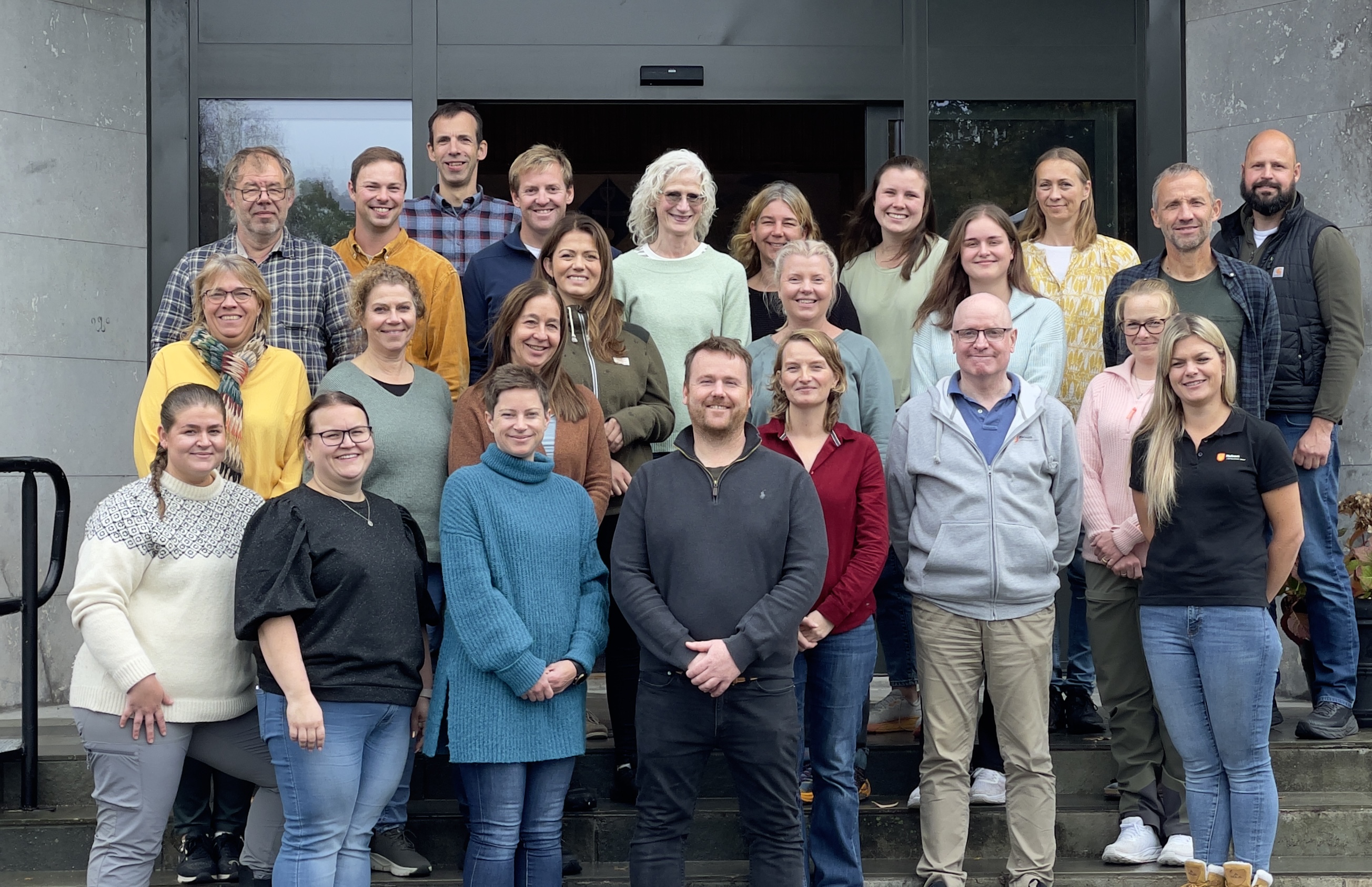 Elever og lærere står i ei trapp ute