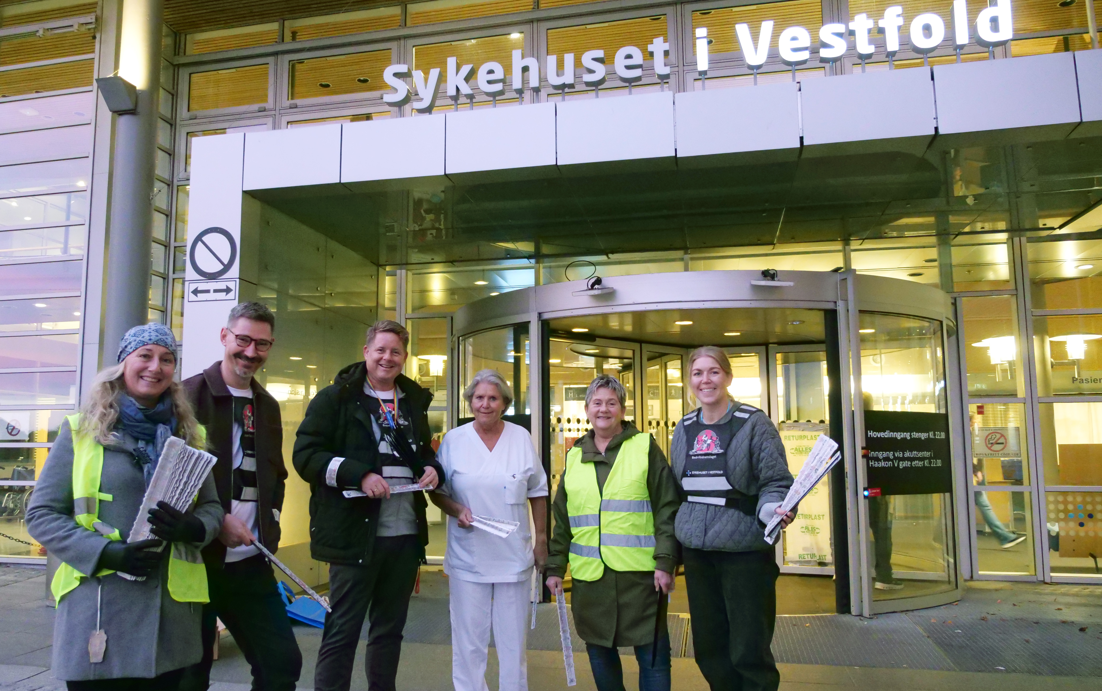 Alle som er på bildet står med refleksbånd foran hovedinngangen til sykehuset i Vestfold.