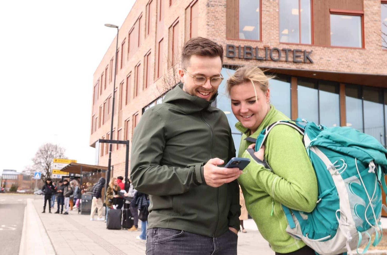 To personer ser på en mobiltelefon