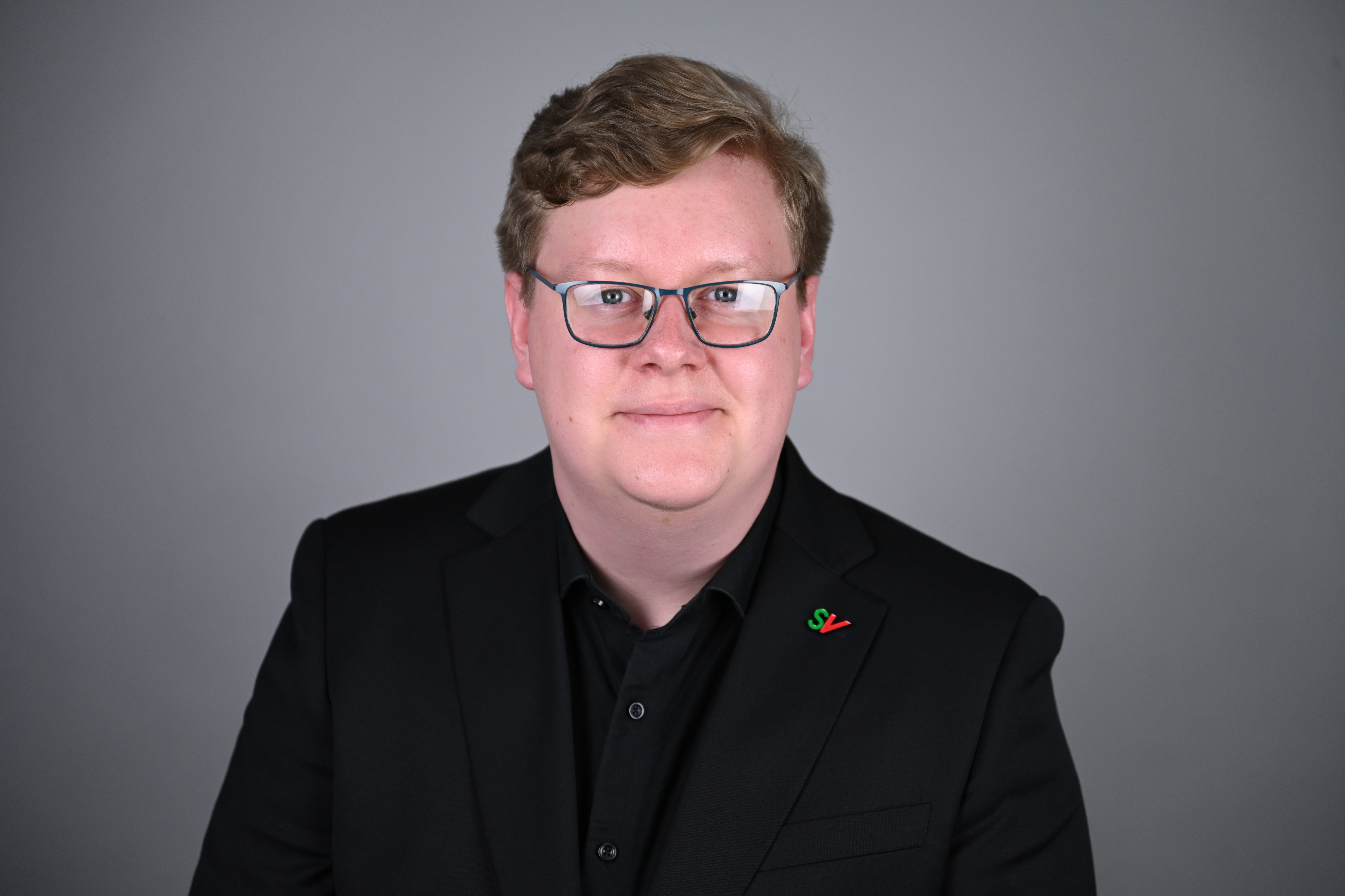 Portrett av mann med grå bakgrunn. Foto: Anders Palmer Holmen