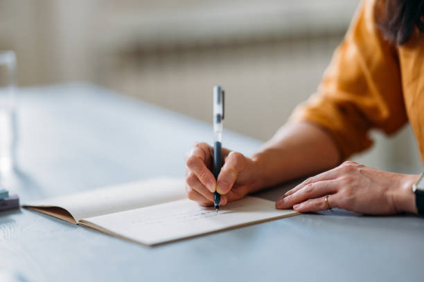 Elev skriver i bok illustrasjonsfoto