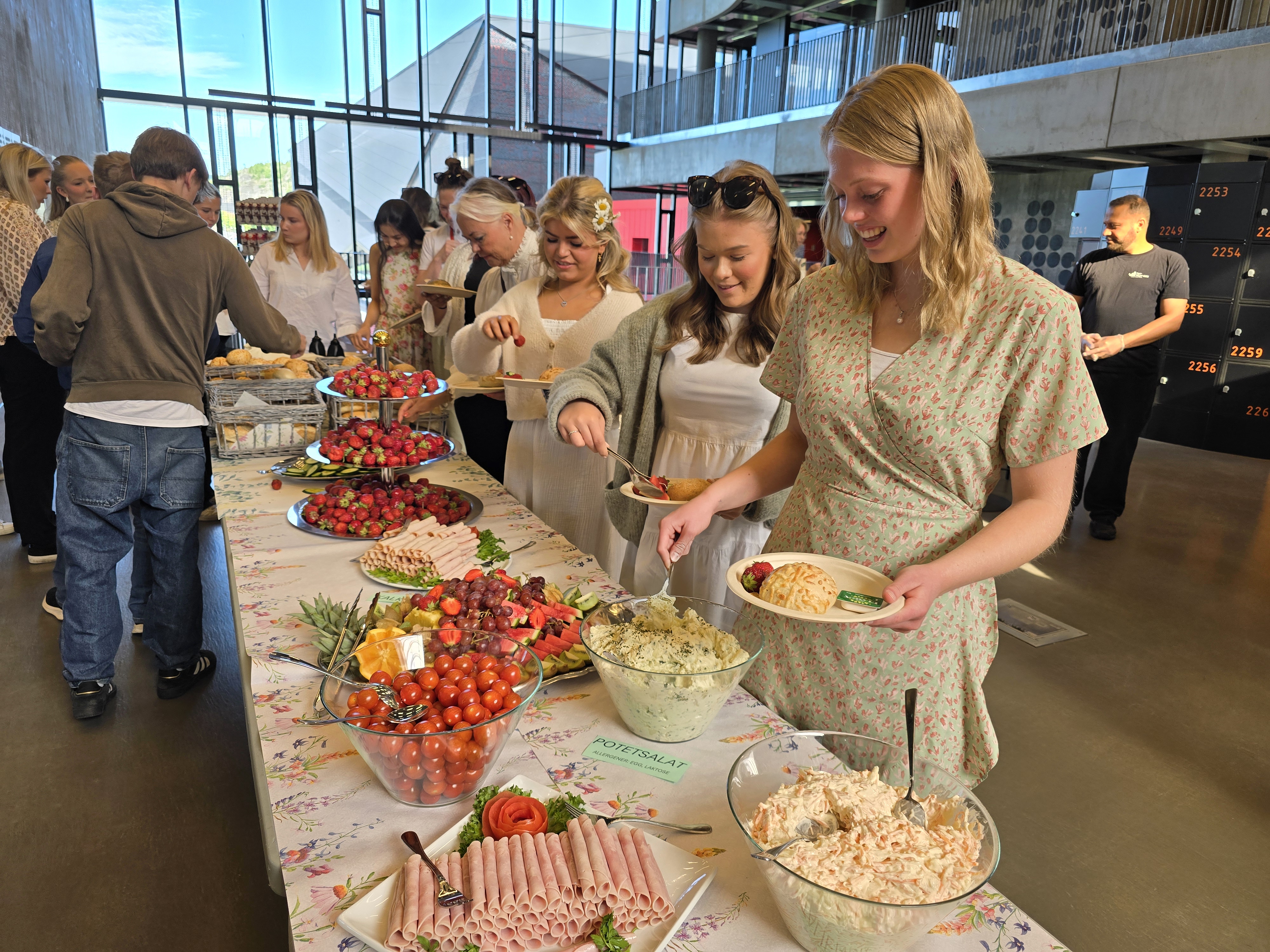 Elever som forsyner seg av mat satt frem på langbord.
