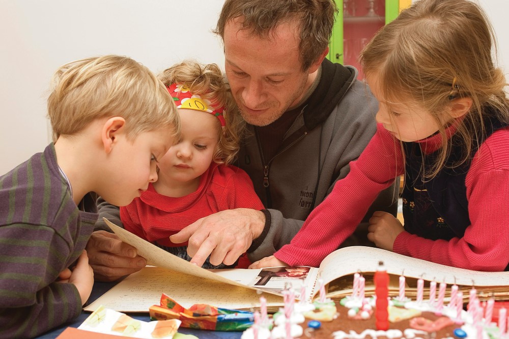 En barnehagelærer som leser for tre små barn