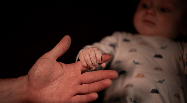 Baby som holder i en finger.