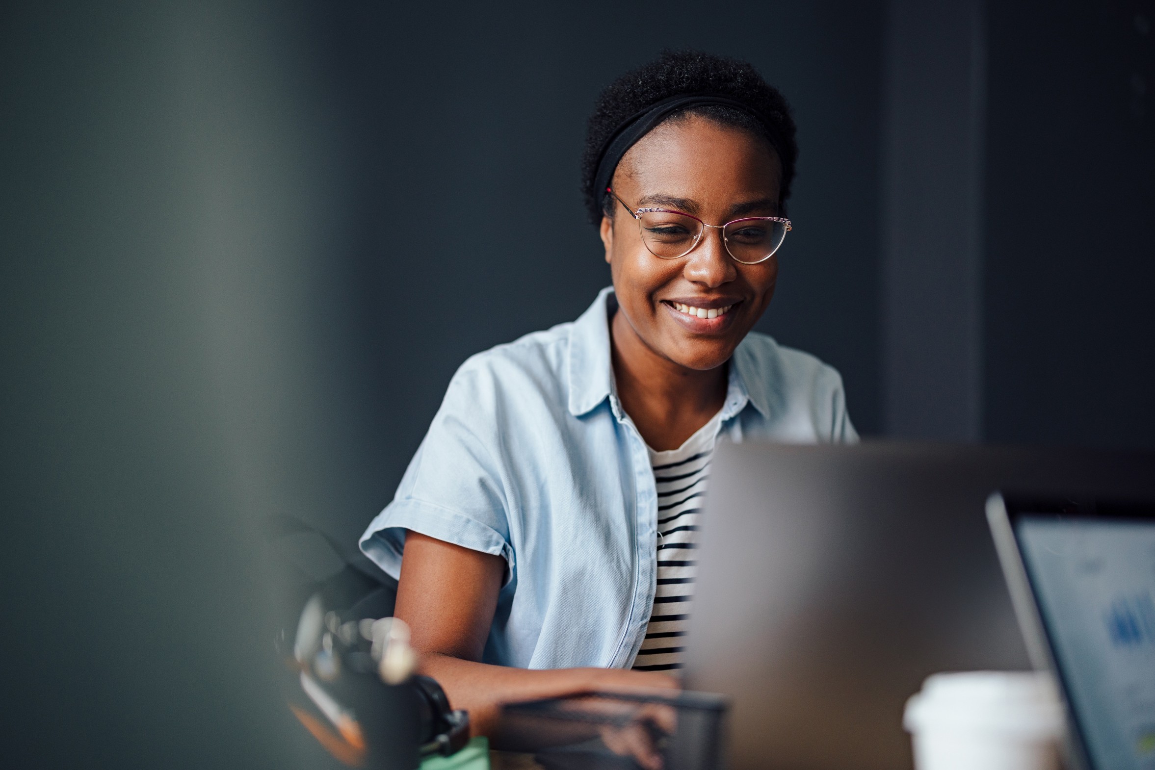 En elev sitter med laptop og ser på skjermen
