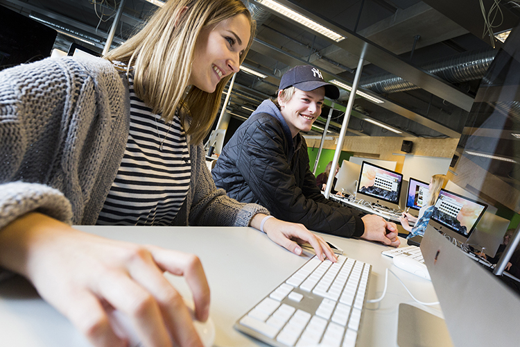 to elever som sitter og jobber på pcen