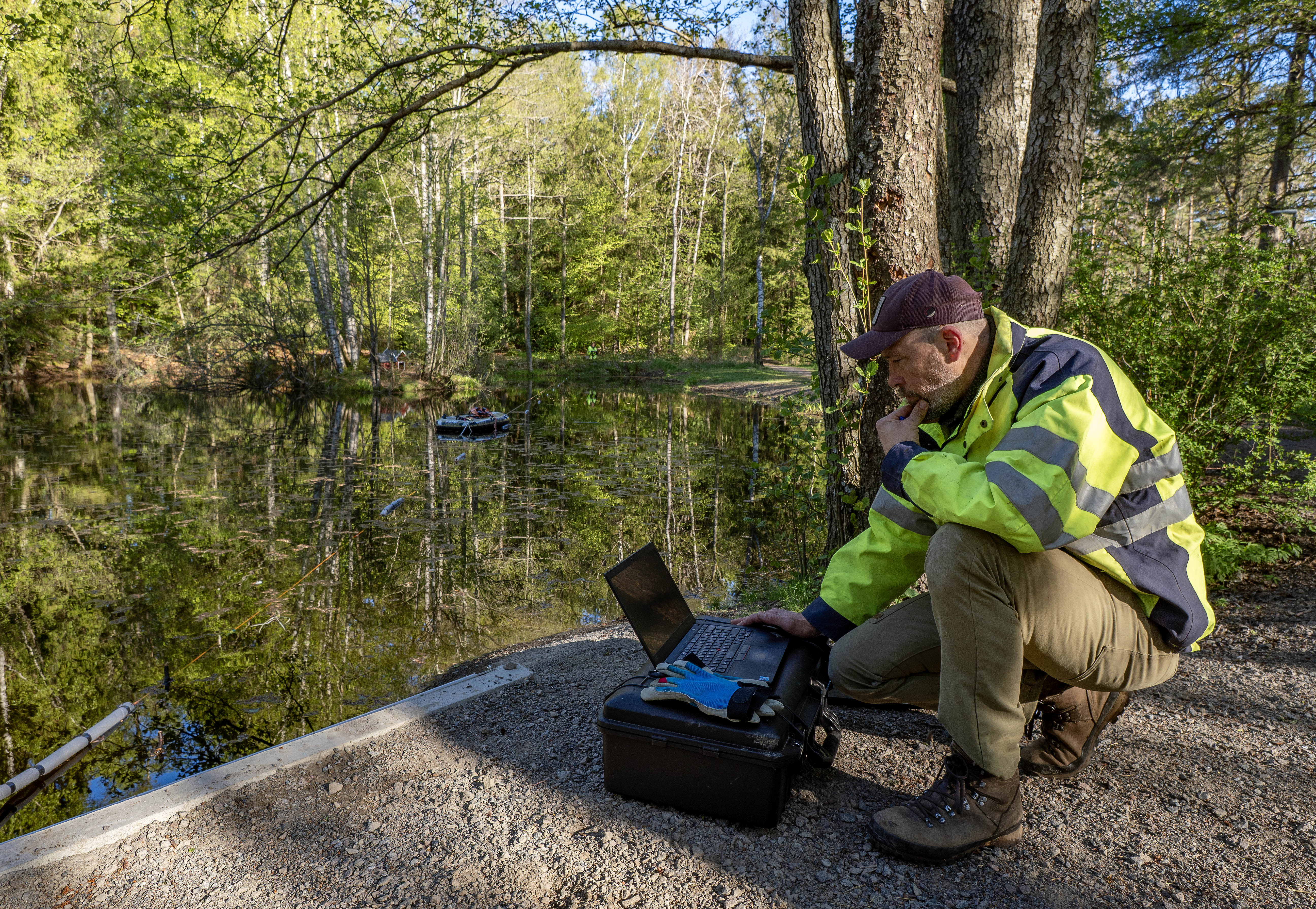 Fotografi av geotekniker fra Cowi som sitter ved et måleinstrument ved Teiedammen