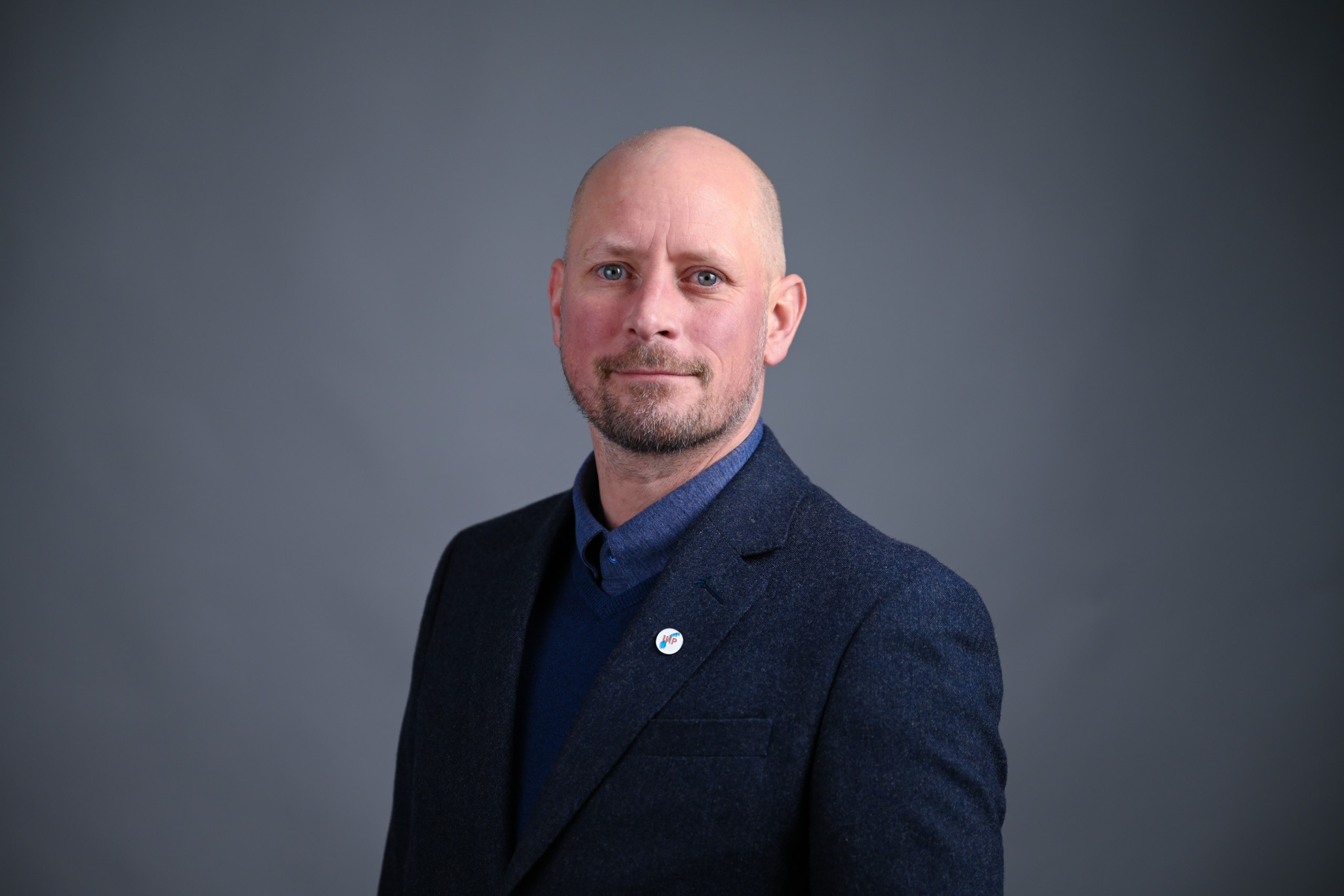 Portrett av mann med grå bakgrunn. Foto: Anders Palmer Holmen