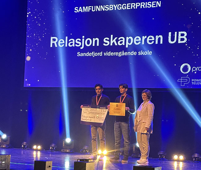 Elever mottar premie på scenen under fylkesmesterskapet.