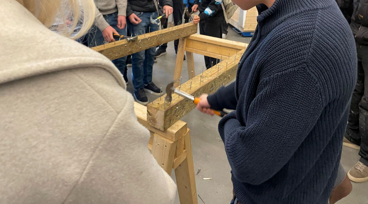 Person som snekrer med mennesker rundt