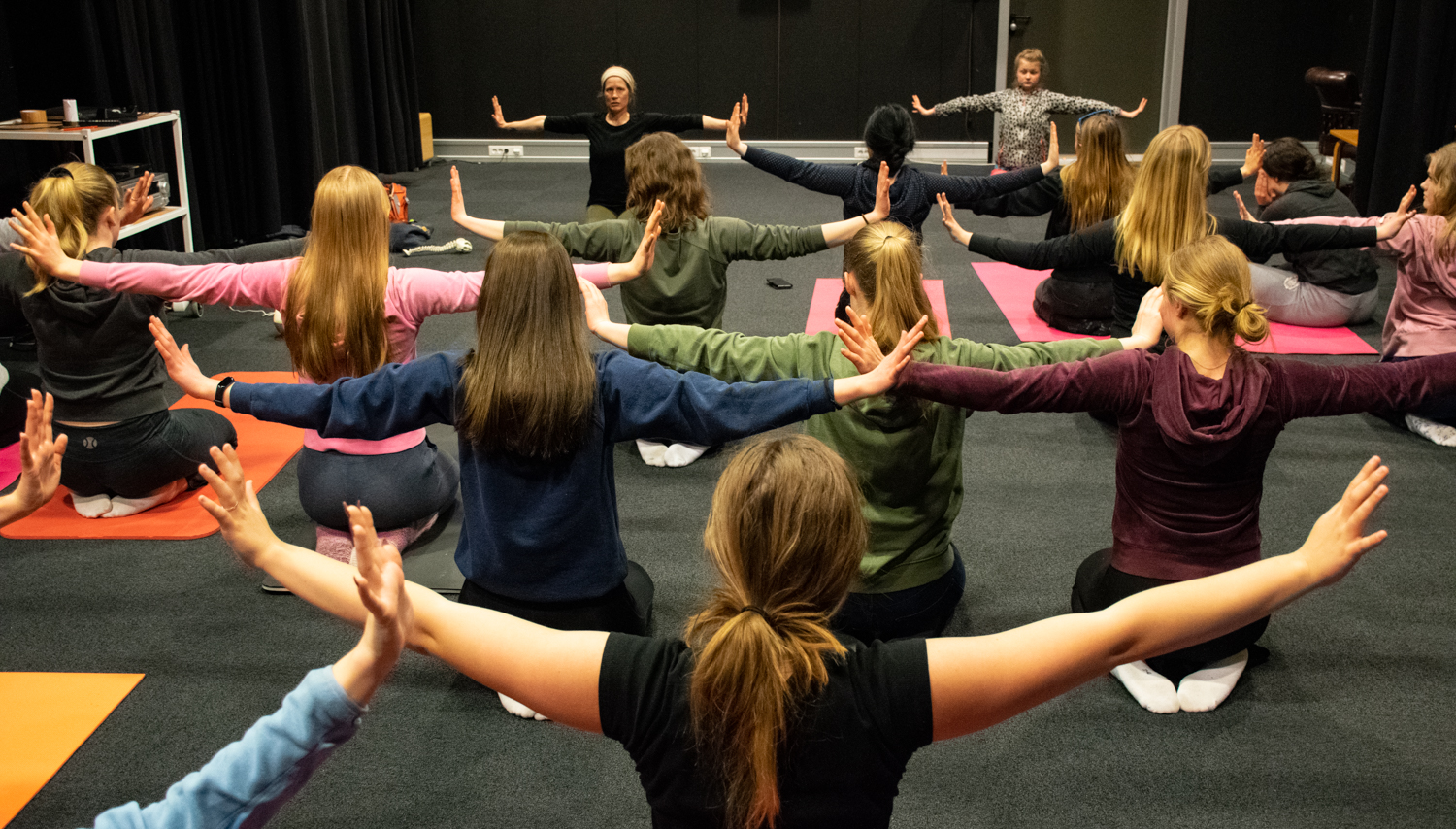 Elever sitter i yogastilling