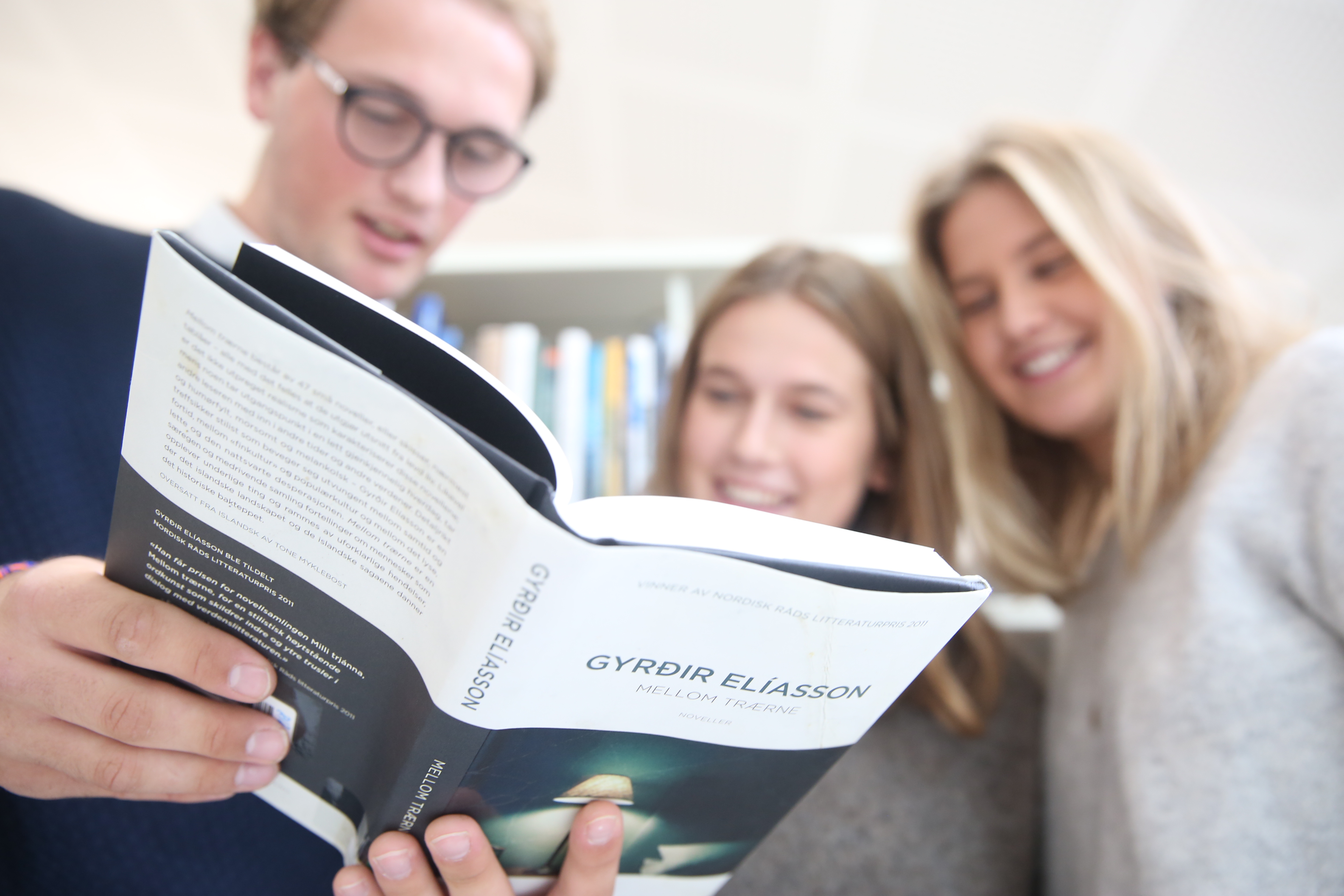 Tre elever leser i en bok