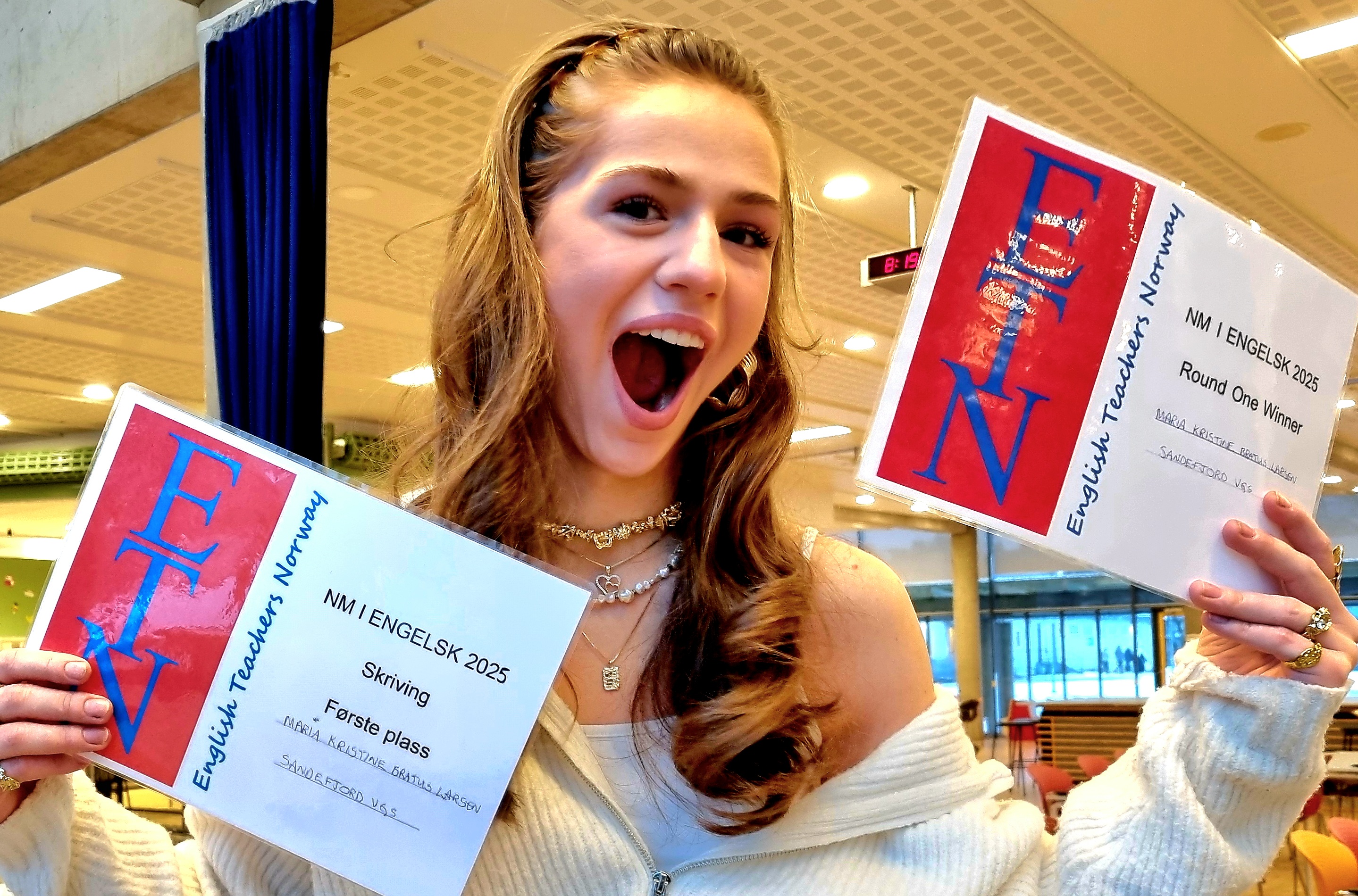 Maria i 3IBA holder diplomene som viser at hun vant NM i engelsk.