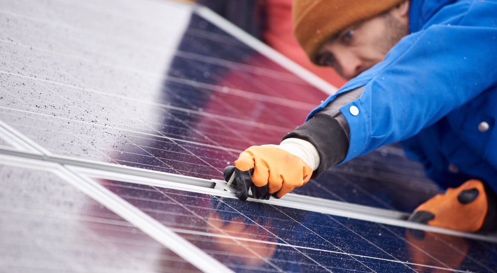 Mann installerer solcellepanel