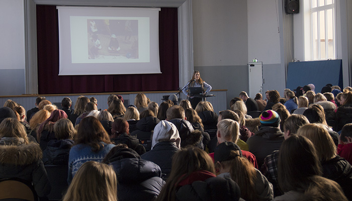 En elev på talestol foran mange elever
