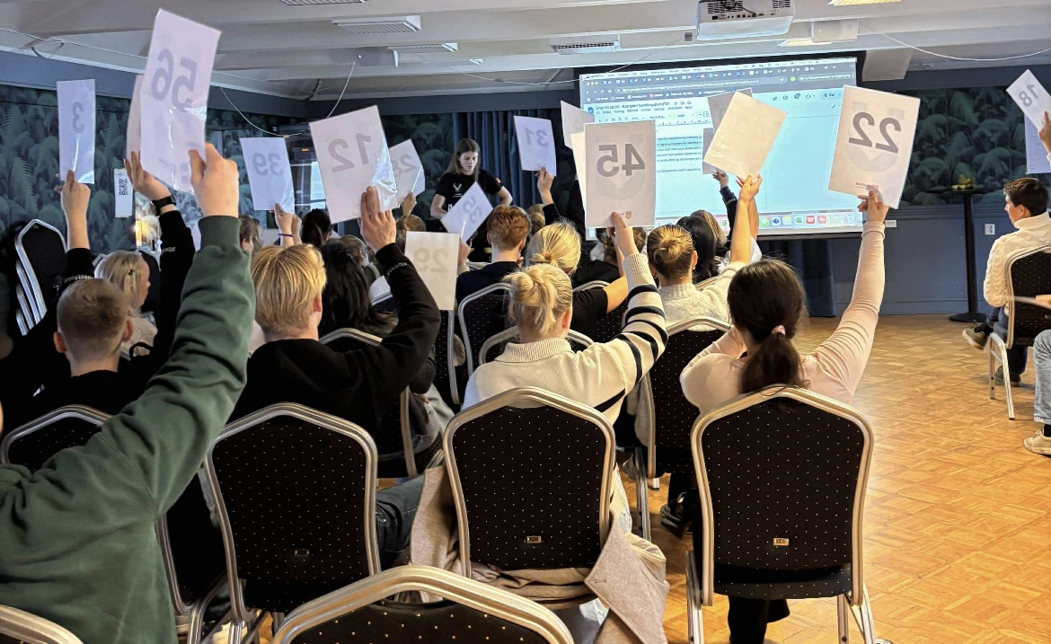 Ungdommer i en sal som stemmer.