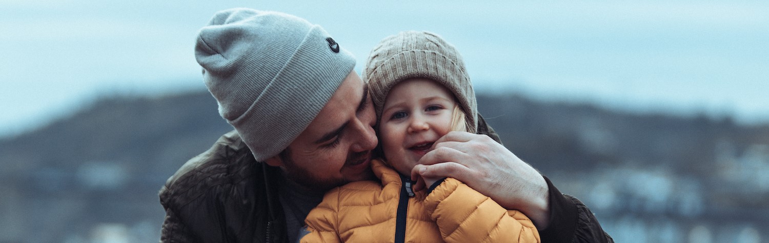 Far og datter klemmer.
