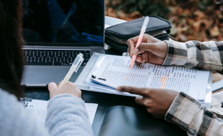 To personer som sitter foran en PC, ansiktene synes ikke.